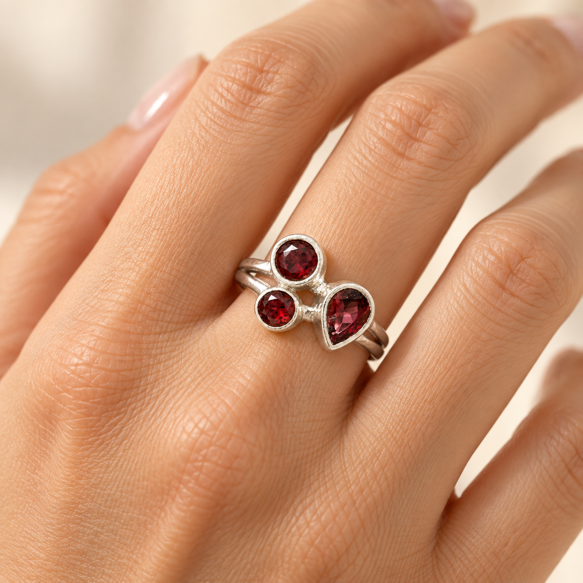 Three-stone garnet sterling silver ring worn on hand