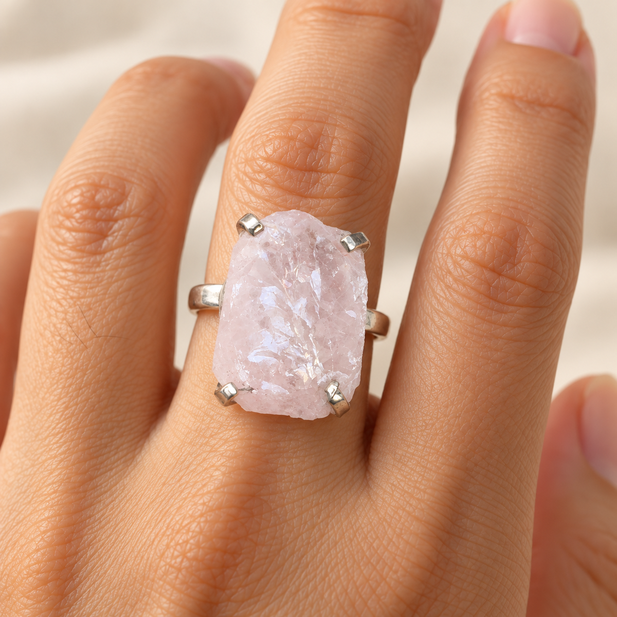 Raw rose quartz ring worn on hand